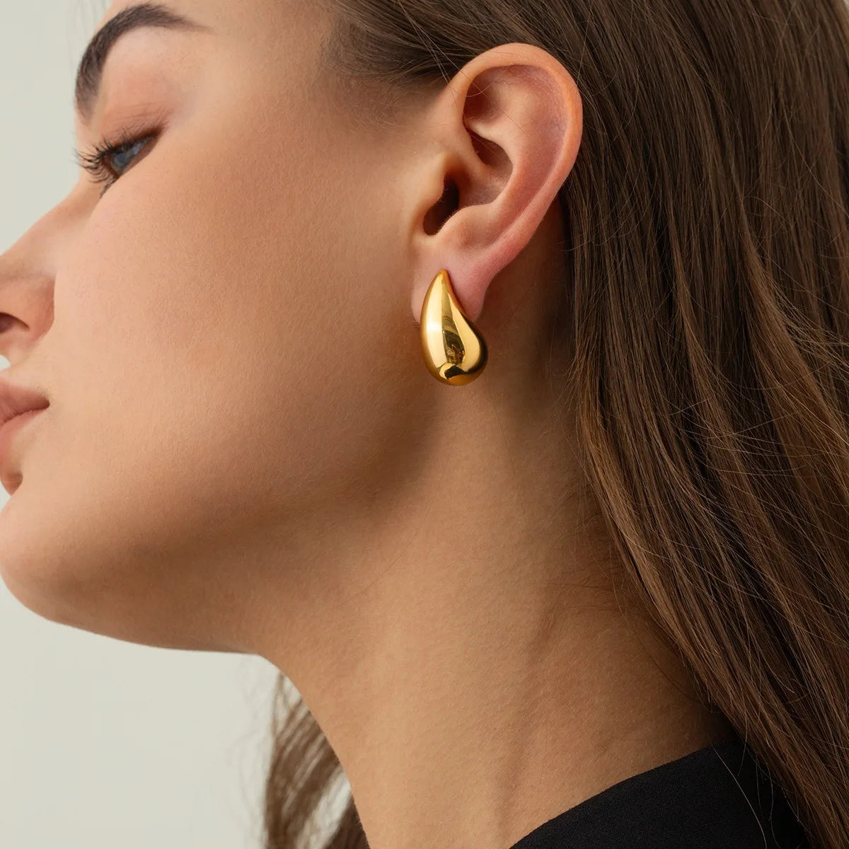 These are  golden, chunky water drop dome stud earrings for women. They're  metal, glossy, thick teardrop-shaped, and designed to be stylish and sexy. Perfect for adding a touch of glamour to your look!