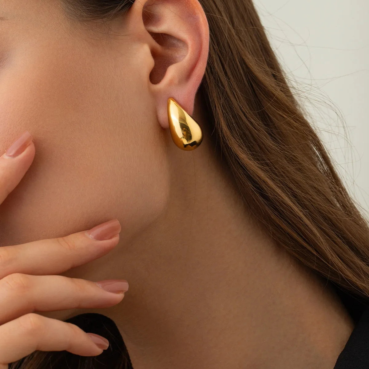 These are  golden, chunky water drop dome stud earrings for women. They're  metal, glossy, thick teardrop-shaped, and designed to be stylish and sexy. Perfect for adding a touch of glamour to your look!