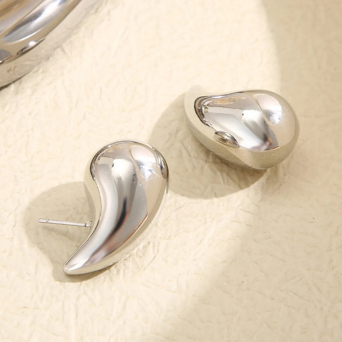 These are  golden, chunky water drop dome stud earrings for women. They're  metal, glossy, thick teardrop-shaped, and designed to be stylish and sexy. Perfect for adding a touch of glamour to your look!