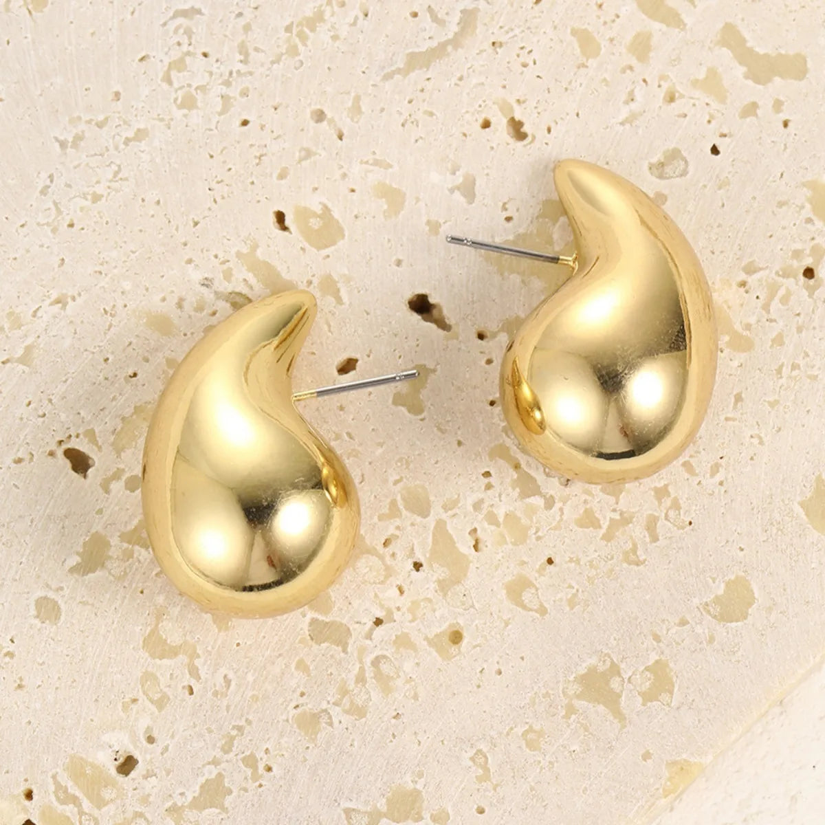 These are  golden, chunky water drop dome stud earrings for women. They're  metal, glossy, thick teardrop-shaped, and designed to be stylish and sexy. Perfect for adding a touch of glamour to your look!